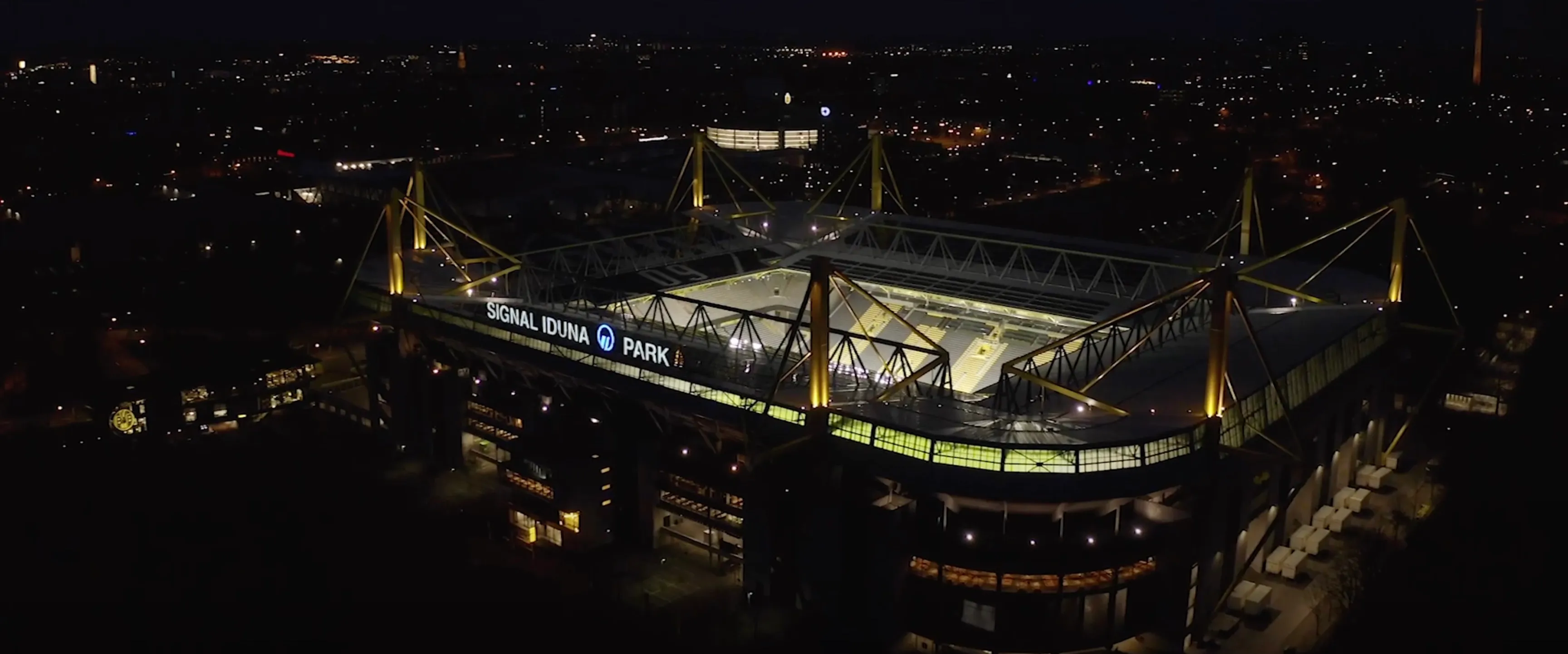 Luftaufnahme eines beleuchteten Fußballstadions bei Nacht